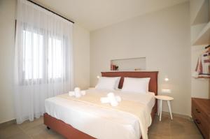 een slaapkamer met een groot bed met witte lakens en witte kussens bij Borgo Nuovo in Rhodos-stad +30 foto's