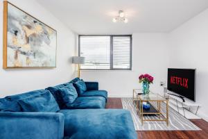 sala de estar con sofás azules y TV en 2-Bed Apartment Near Basildon Train Station en Basildon