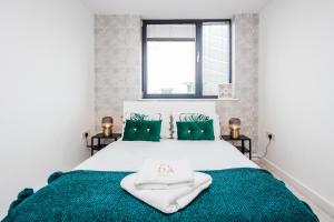 a bedroom with a large white bed with green blankets at 2-Bed Apartment Near Basildon Train Station in Basildon