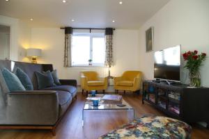 a living room with a couch and a tv at Burgess Yard 2-bedroom cottage, Bath in Bath