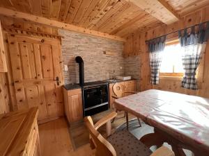 uma cozinha com uma mesa e um fogão numa cabina em Kilge Alm em Grosskirchheim