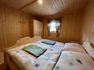 sypialnia z 2 łóżkami w drewnianym pokoju w obiekcie Kilge Alm w mieście Großkirchheim