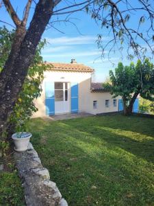 Biały dom z niebieskimi drzwiami i ogródkiem w obiekcie Nid douillet - LES FARGETTES - superbe vue - charmante petite maison avec jardin - 2 pièces à Privas w mieście Privas