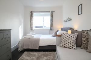 a bedroom with a bed and a window and a couch at Burgess Yard 2-bedroom cottage, Bath in Bath