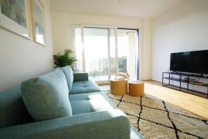 sala de estar con sofá azul y TV en Oberlaa New Apartment - 15 Min to City, en Viena