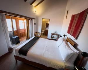 a bedroom with a large white bed in a room at El Balcón in Cusco