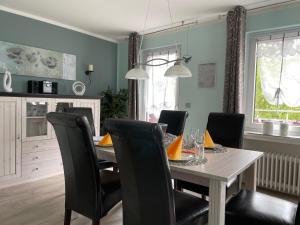a dining room with a table and black chairs at Ferienhaus SweetHome - eingezäunter Garten - 3 Hunde willkommen - ruhige Sackgasse in Bad Sachsa