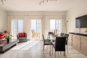 a living room with a dining room table with chairs at Exclusive Villa - Great Sea View in Nerja
