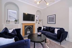 a living room with two blue couches and a table at Granton Place in Aberdeen
