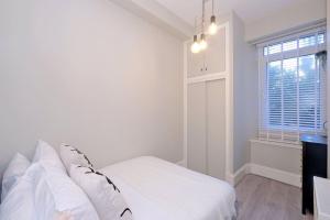 a white bedroom with a bed and a window at Granton Place in Aberdeen