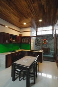 a kitchen with a table and a green wall at Le Robinet Villa - a journey into Hue citadel soul in Hue