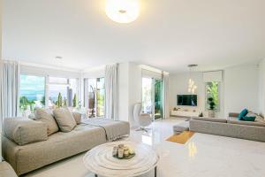 een woonkamer met een bank en een tafel bij White Pearl Premium Villa Corfu in Evropoúloi