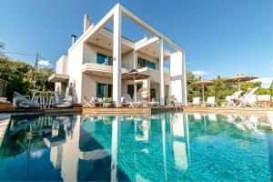 een huis met een zwembad ervoor bij White Pearl Premium Villa Corfu in Evropoúloi