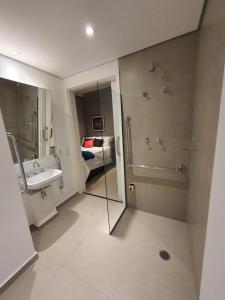 a bathroom with a sink and a shower and a bed at Studio Allianz Perdizes in Sao Paulo +7 photos