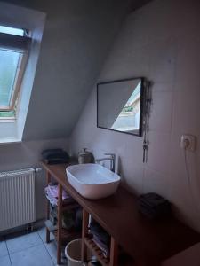 een badkamer met een witte wastafel op een houten aanrecht bij Kleine Auszeit in Trebbin