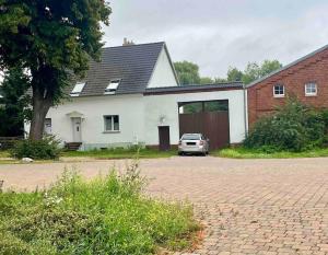 een witte auto geparkeerd voor een huis bij Kleine Auszeit in Trebbin