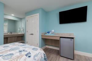 a bedroom with a bed and a tv on the wall at Bluff's Landing Marina & Lodge in Flour Bluff
