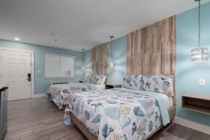 two beds in a bedroom with blue walls at Bluff's Landing Marina & Lodge in Flour Bluff