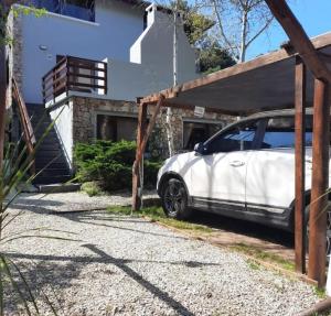 un coche blanco estacionado frente a una casa en Nereidas Apart en Mar de las Pampas