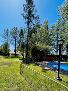 a fence in front of a yard with a pool at WINEHOUSE in Chacras de Coria