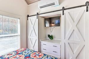 una puerta corredera de un granero en un dormitorio con cama en Tiny Home Retreat with Fire Pit about 3 Mi to Lake! en Morganton