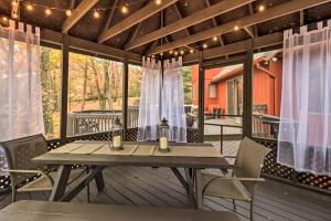una terraza de madera con mesa y sillas en Pet-Friendly Poconos Retreat with Outdoor Theater! en Lake Harmony