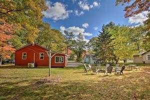 un patio con sillas y una casa roja en Idyllic Finns Retreat - Walk to Lake Huron, en Oscoda