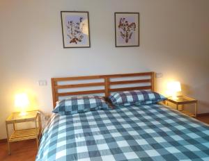 una camera con un letto a scacchi blu e bianco con due lampade di Le Masserie Case Vacanza a Villetta Barrea