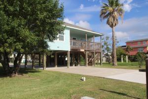 a house with a balcony and a palm tree at Bluff's Landing Marina & Lodge in Flour Bluff