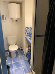 Łazienka z toaletą i niebieską podłogą wyłożoną kafelkami w obiekcie Escale à Brest même. w mieście Brest