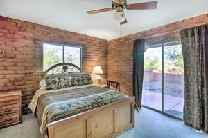 a brick walled bedroom with a bed and a ceiling fan at Tucson Home - Hiking Trail Access On-Site! in Avra