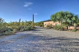 a gravel road with a building and palm trees at Tucson Home - Hiking Trail Access On-Site! in Avra