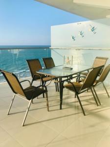 a dining room with a glass table and chairs at Vacaciones Playa Azul in Tonsupa