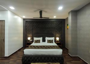 Hotel Red Castle - Karol Bagh في نيودلهي: غرفة نوم مع سرير كبير مع اللوح الأمامي الأسود