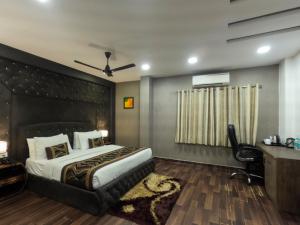 a bedroom with a bed and a desk and a chair at Hotel Red Castle - Karol Bagh in New Delhi