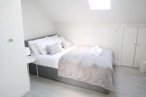 a bedroom with a bed with two towels on it at Twelve Thirty Serviced Apartments - 1 Croydon in South Norwood