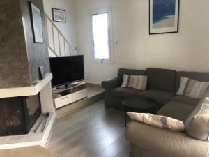 a living room with a couch and a fireplace at Maison landaise moderne avec piscine chauffée et spa in Lit-et-Mixe