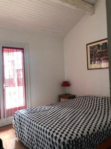 a bedroom with a bed with a black and white checkered blanket at Maison landaise moderne avec piscine chauffée et spa in Lit-et-Mixe +28 photos