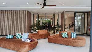 three brown couches in a living room at Hi Chiangmai Hotel in Chiang Mai