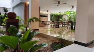 uma sala de estar com plantas e uma sala de jantar em Hi Chiangmai Hotel em Chiang Mai