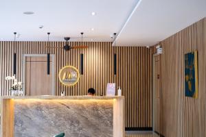 a person sitting at a counter in a room with wooden walls at Hi Chiangmai Hotel in Chiang Mai
