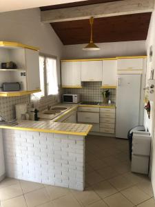 a kitchen with white cabinets and a white refrigerator at Maison landaise moderne avec piscine chauffée et spa in Lit-et-Mixe
