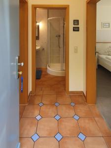 a bathroom with a shower and a tiled floor at Ferienwohnung am Dresdner Elbhang in Dresden