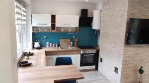 a kitchen with white cabinets and a blue wall at Dobry Dom I in Staszów