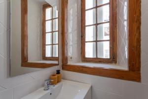 a bathroom with a sink and two windows at Loft Mouraria in Lisbon +11 photos