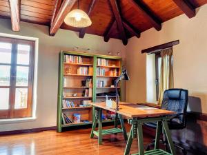 a room with a desk and a book shelf with books at Fyllosia Villa Part of Cretan Retreat in Archanes +33 photos