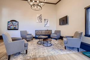 a waiting room with chairs and a table and a tv at Lift House Lodge, Downtown Lionshead, Premium Studio Condo in Vail