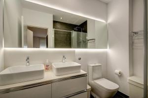 a bathroom with two sinks and a toilet and a mirror at Beds & Breaks Torrealba in Valencia
