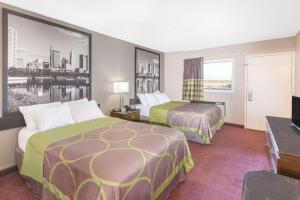 a hotel room with two beds and a flat screen tv at Super 8 by Wyndham Millbury/Toledo in Millbury