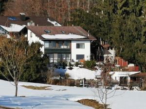 a large white house in the snow at Ferienwohnung am Moosweg in Siegsdorf
